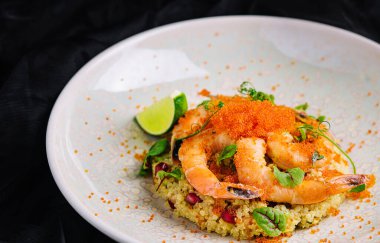 Kırmızı havyar altında karides ve sebzeli kuskus.