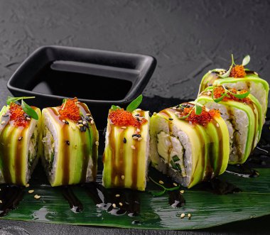 Suşi peyniri siyah tahtada yuvarlanıyor.