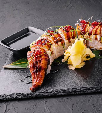 Canadian roll with eel, cheese cream and avocado on black