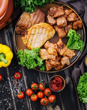 Koyu ahşap üzerinde ızgara et çeşitleri.