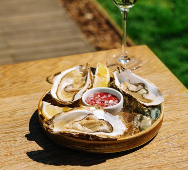 Opened oysters and lemon with white wine on the table
