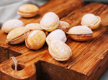 Walnut shaped cookies with caramel on wood