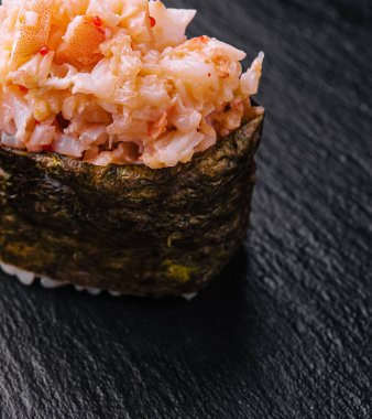 Siyah masada baharatlı ton balıklı Gunkan suşisi.