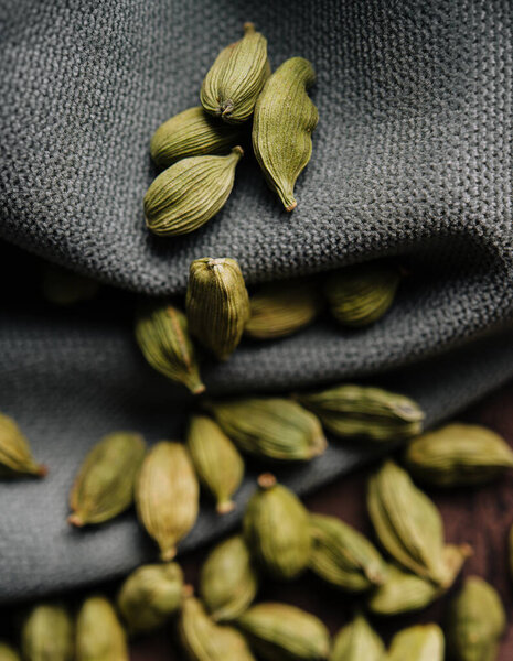Зеленый ароматический кардамон на ткани крупным планом