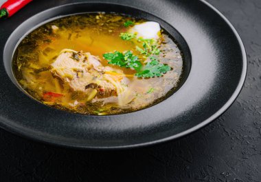 Siyah tabakta tavuk çorbası.