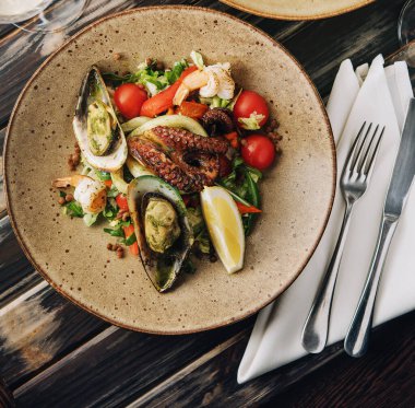 Tahta masadaki deniz ürünleri tabakları.