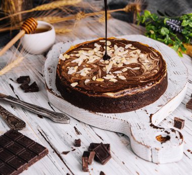 Cocoa brownies pouring with melted dark chocolate