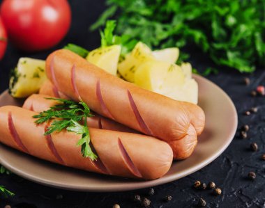 boiled sausages with potatoes on plate