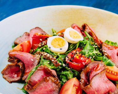 Veal carpaccio with arugula and eggs