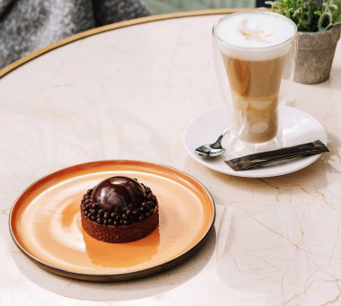 Açık kafedeki masada kahve ve kek.