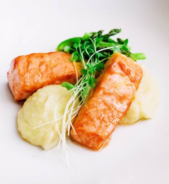 salmon steaks with mashed potatoes on white plate