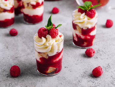 Layered dessert Trifle with vanilla cake, whipped cream and fresh raspberries