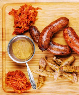 Ahşap masada leziz ızgara sosisler.