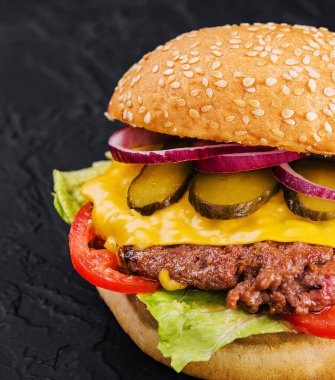 Siyah arka planda taze lezzetli bir burger.