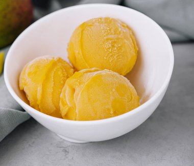 Mangolu dondurma ve mango parçaları.