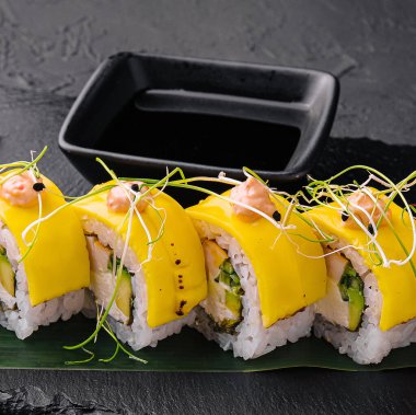 Vegan yellow maki sushi rolls on stone