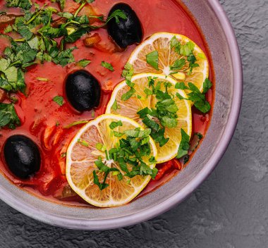 red soup Solyanka, with sausage, olives and lemon