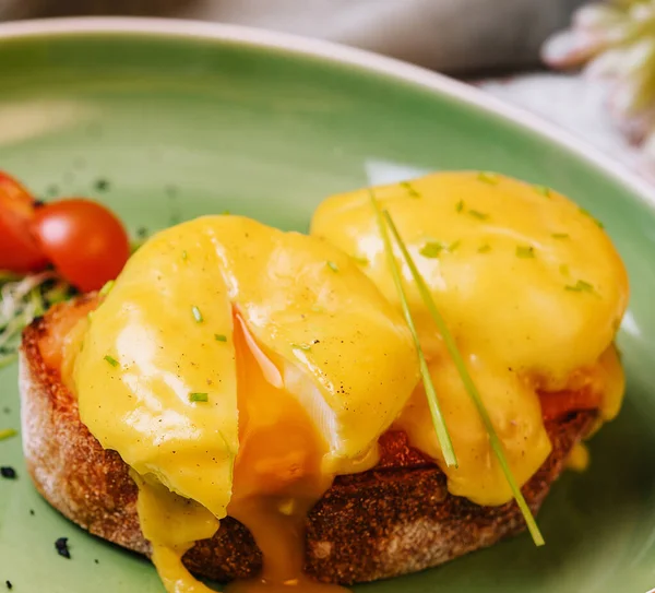 stock image Classic egg benedict on green plate