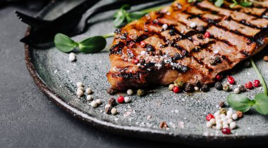 Fried juicy steaks with herbs and spices on plate