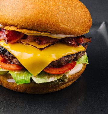 Domuz pastırmalı burger ve siyah tepside köfte.