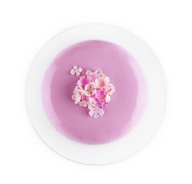 Çiçeklerle süslenmiş aynalı mor kremalı kek.