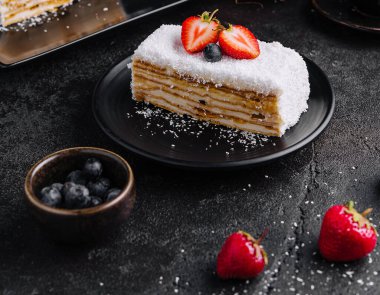 Coconut Cake slice with strawberries and blueberries