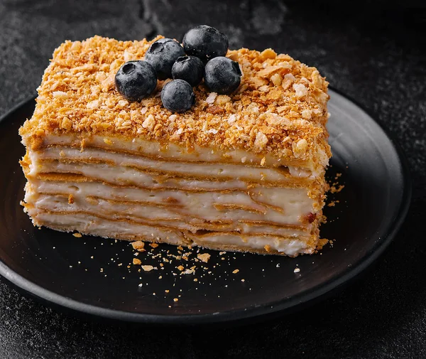 cake napoleon with blue blueberries and tea cup