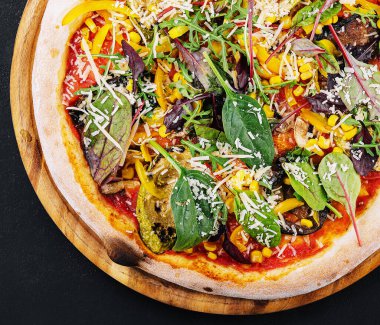 Vegetarian pizza with arugula, eggplant, mushrooms and corn