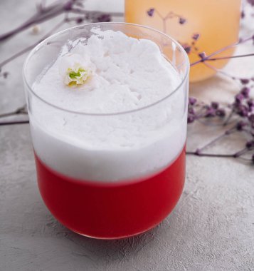 red cocktail with a white foam on top