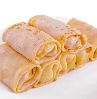 Rolls of pancakes on white plate