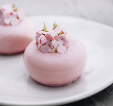 Pink mousse cakes decorated on white plate