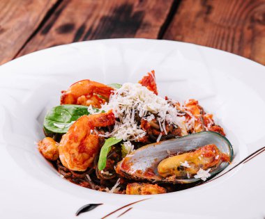 siyah beyaz tabakta su ürünleri spagetti