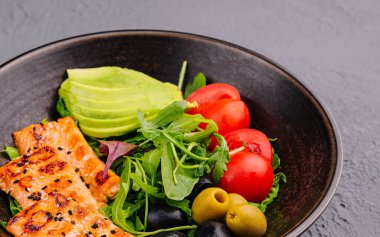 salad with grilled salmon, avocado, tomatoes with arugula