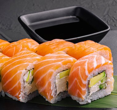 Set of salmon sushi rolls on stone board