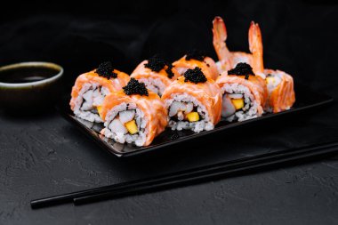 Sushi roll with fried salmon, shrimp and black caviar