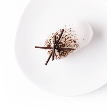 White mousse cake on white plate top view