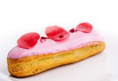 eclairs with pink raspberry glaze on white plate