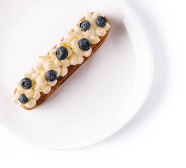 Eclair with vanilla cream and blueberries