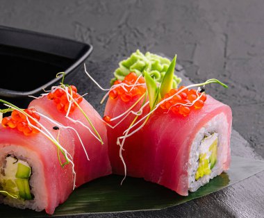 sushi rolls of red tuna on black stone