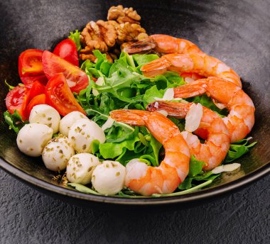 Salad with fresh arugula leaves, mozzarella cheese and shrimps