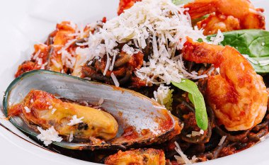 siyah beyaz tabakta su ürünleri spagetti