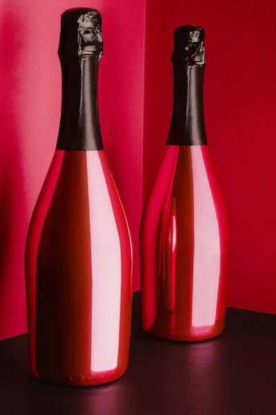 Δύο Κόκκινα Μπουκάλια Σαμπάνιας Κόκκινο Φόντο — Φωτογραφία Αρχείου