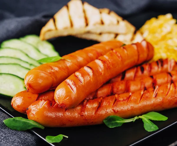 English breakfast - fried eggs, sausage, cucumber and toasts