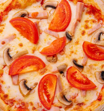 Jambonlu, domatesli ve mantarlı pizza.