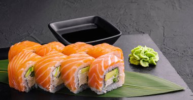 Set of salmon sushi rolls on stone board