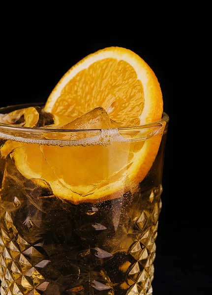 Old-fashioned cocktail with ice and orange slice