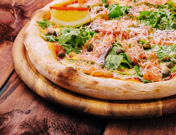 Italian Pizza with salmon, arugula and capers