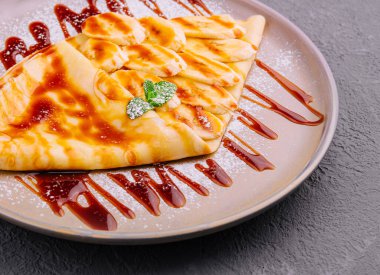 pancakes with banana and strawberry jam on a plate