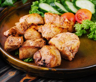 Seramik kasede ızgara tavuk ve salata.