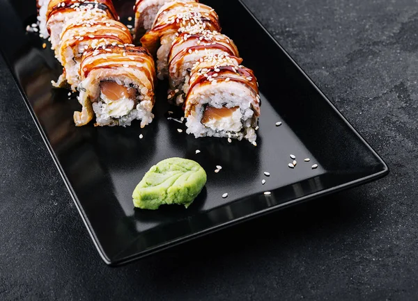 stock image Sushi eel roll maki on black plate